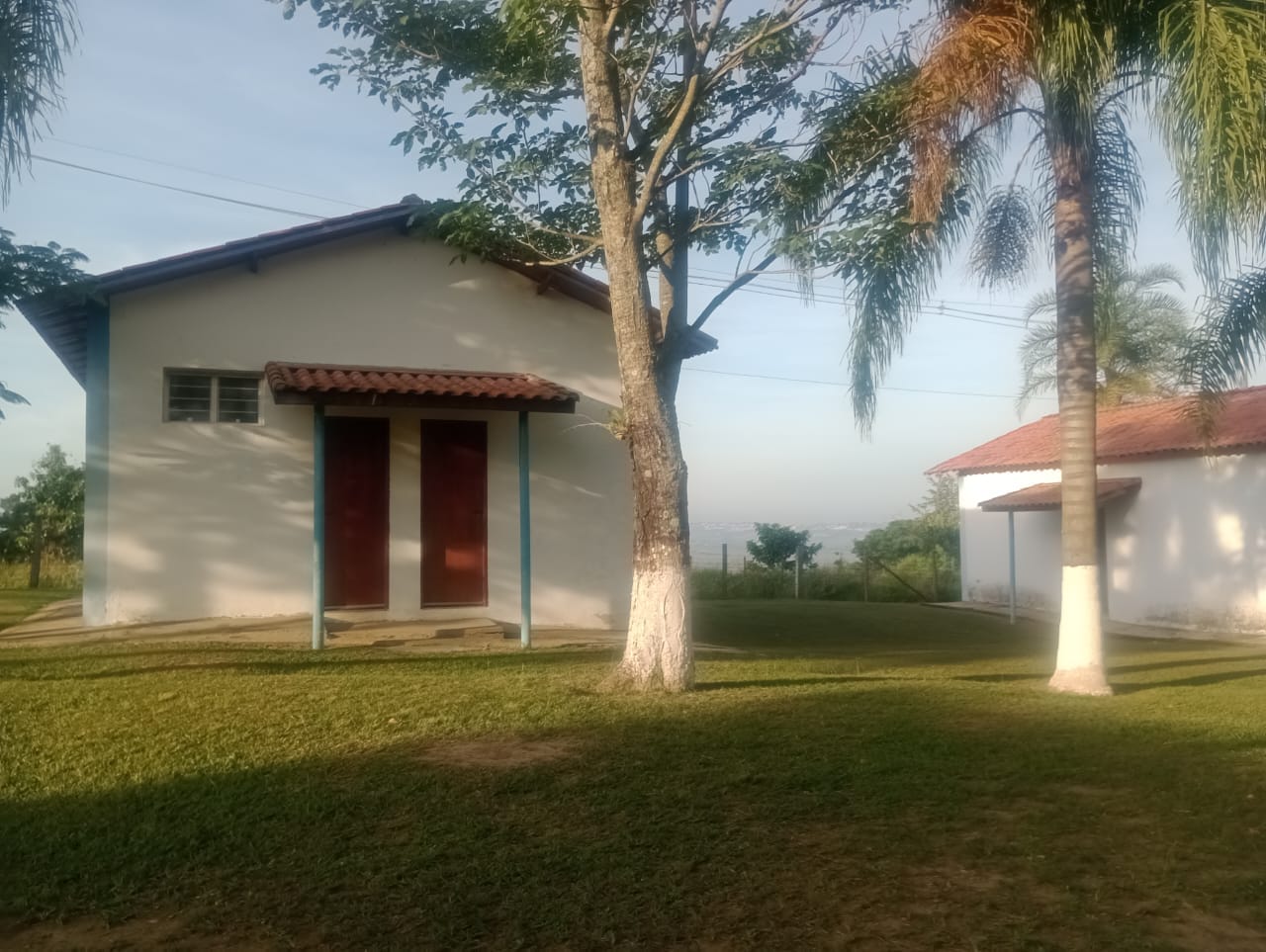 Casa do Espaço Campestre Wannel com telhado vermelho cercada de árvores
